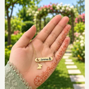 Butterfly name locket in golden brass held in hand